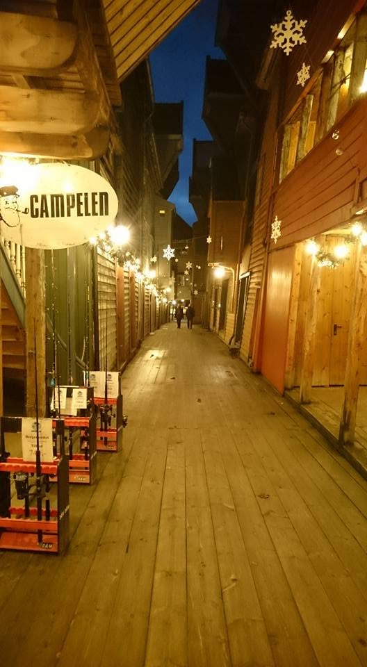 Passasjen på Bryggen en vinterkveld, med Campelen-skiltet og lys langs husveggene