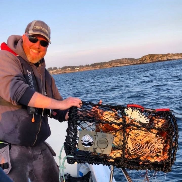 Fisker drar en krabbeteine om bord i båten